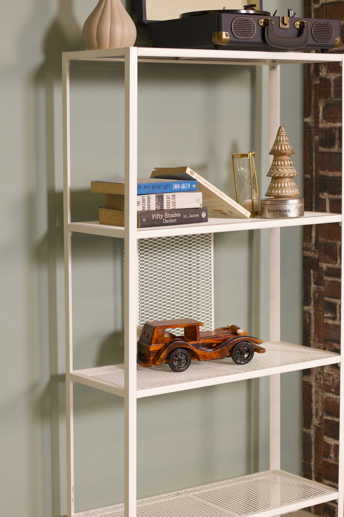 Shelf styling against the sage green wall